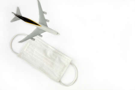 Travel and health concept during covid-19 pandemic. passenger airplane and white masks isolated on white background, travel,coronavirus concept with copy spaceの写真素材