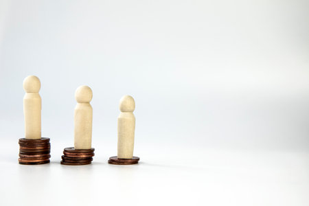 Miniature people standing on piles of different heights of coins. The concepts of person and wealth....