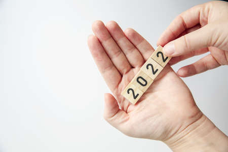 Persons hand holding 2022 on white background top view a minimal concept with copy space. Happy new yearの写真素材