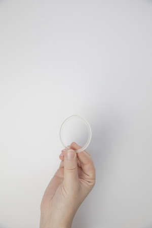 Birth control ring in a womans hand isolated on white background, vaginal ring for contraceptive use close-upの写真素材