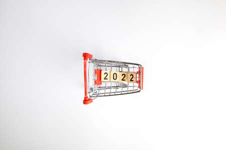 Shopping cart and numbers 2022 isolated on white background, Shopping for the new year, christmas and black friday. New Years discounts, sale. top view with copy spaceの写真素材