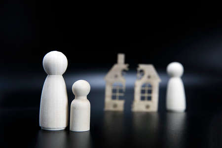 Divorce, division of property, poverty and no money concept. Wooden broken house on black background. Mortgage, rent, realtor concept copy spaceの写真素材