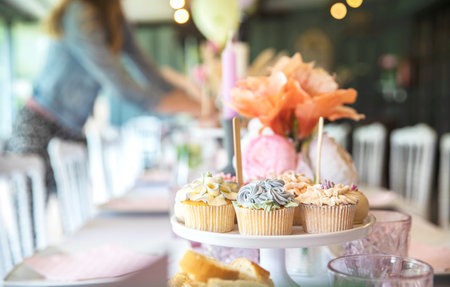 Fresh cupcakes with whipped cream and devorative flower icing served on a plate on party table, wedding,baby shower,high tea, Birthday holiday backgroundの写真素材