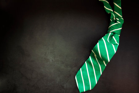 stylish tied green striped tie on dark concrete background top view, copy space, men,business,meeting,party concept maleの写真素材