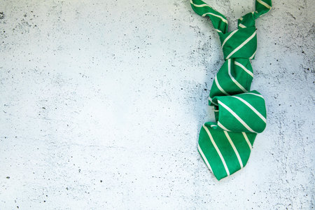 stylish tied green striped tie on concrete white background top view, copy space, men,business,meeting,party concept maleの写真素材