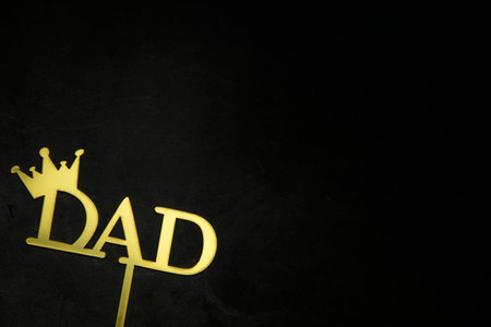 Happy Fathers Day concept. Gold shiny Letters with text Happy Father's Day on concrete dark black background Flat lay, top view, copy space king crownの写真素材