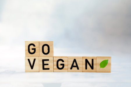 Go vegan text with fresh with green leaf on wooden cubes. Veganism, vegetarian,health,green,eco movement concept. copy space space for textの写真素材