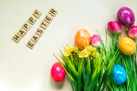 Happy Easter text with colorful pained easter eggs in fresh green grass, Animation, colorful Easter eggs and text on a light background. Video for presentation of Happy Easter. topviewの写真素材