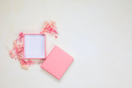 Open and closed pink gift box place for product on bright background with flowers .Flat lay, top view, mock-up gift,present Mothers Day,Valentines Day,Birthday concept copy spaceの写真素材