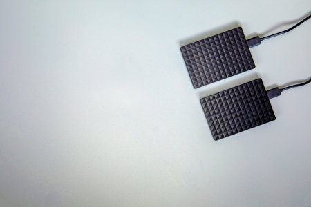Portable black Hard Drive HDD isolated on grey background. Cool flat lay top view, copy space. Data...