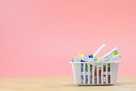 Full shopping basket on wooden table, food and groceries in shopping basket on pink background, copy space space for textの写真素材