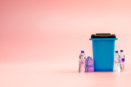 trashbin. Blue dustbin for recycle plastic trash isolated on pink background. Container for disposal garbage waste and save environment with plastic bottles copy spaceの写真素材