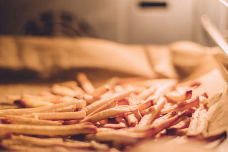 just cooked french fries in the oven - rustic food and homemade cooking styled concept