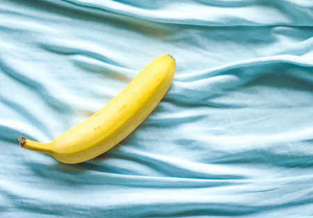 ripe banana on blue background - fresh fruits and healthy eating styled concept, elegant visualsの写真素材