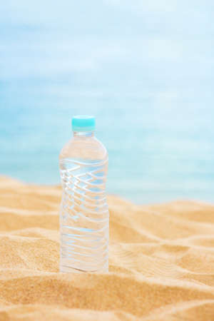 drinks, summertime and environment concept - bottle of water on the beach, elegant visualsの写真素材