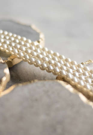 Pearl necklace on golden marble, ethical jewellery - luxury background, jewelry as a gift concept. Pearls are girl's best friendsの写真素材