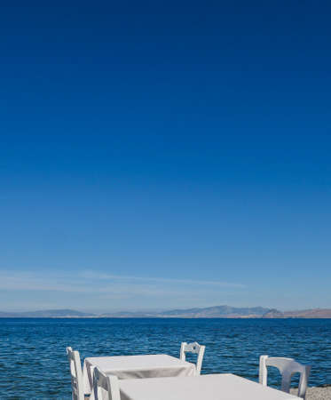 White restaurant tables on the beach in summer - travel, vacation and summer concept. The perfect...