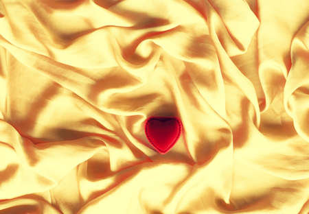 Red heart shaped jewellery gift box on golden silk - Valentine's day, true love, engagement and...