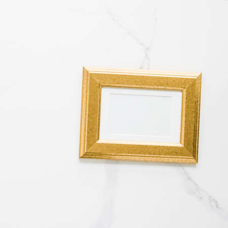 Golden photo frame on marble, flatlay - modern feminine, artwork mock up, luxury design concept....
