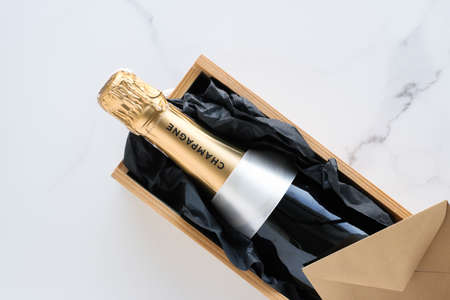 Wedding celebration, lifestyle and luxury present concept - A champagne bottle and a gift box on marbleの写真素材