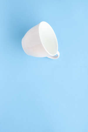 Kitchen, dishware and drinks concept - Empty cup and saucer on blue background, flatlayの写真素材