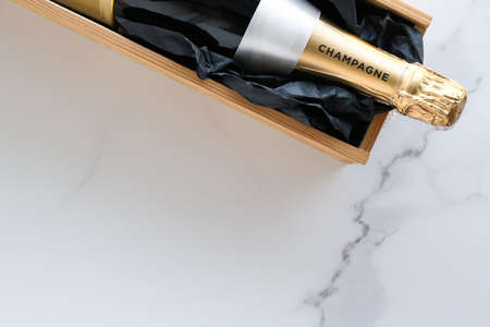 Wedding celebration, lifestyle and luxury present concept - A champagne bottle and a gift box on marbleの写真素材