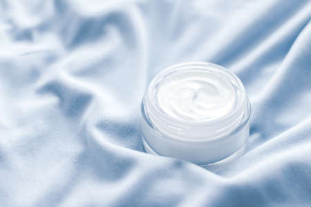 Beauty, anti-age cosmetics and skincare concept - Luxury face cream jar on blue silk