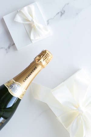Wedding celebration, lifestyle and luxury present concept - A champagne bottle and a gift box on marbleの写真素材