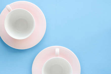 Kitchen, dishware and drinks concept - Empty cup and saucer on blue background, flatlayの写真素材