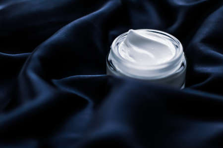 Beauty, anti-age cosmetics and skincare concept - Luxury face cream jar on a dark blue silkの写真素材