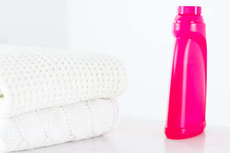 Housekeeping, fabric textures and handmade knitwear concept - Warm knitted clothes and liquid laundry detergentの写真素材