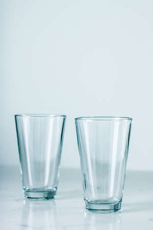 Glassware, washing and purity concept - Clean empty glasses on marble tableの写真素材