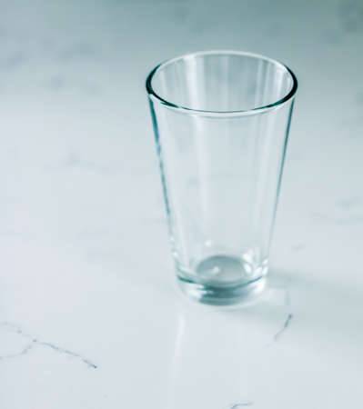Glassware, washing and purity concept - Clean empty glass on marble tableの写真素材