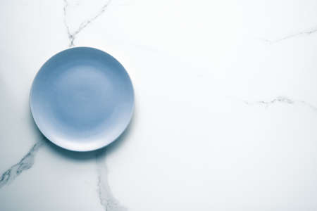 Blue empty plate on marble, flatlay - stylish tableware, table decor and food menu concept. Serve...