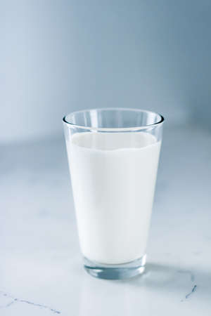 Dairy, healthy nutrition and breakfast concept - World Milk Day, full glass on marble tableの写真素材