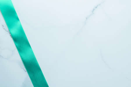 Holiday design, greeting card and vintage gift concept - Green silk ribbon on marble background, top viewの写真素材