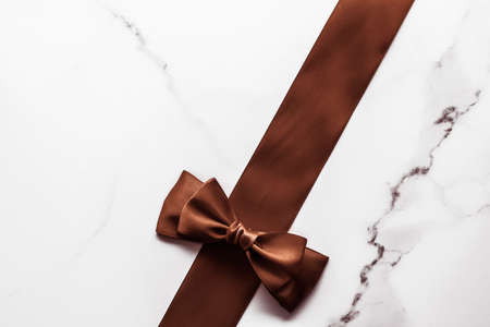 Holiday gift, decoration and sale promotion concept - Chocolate brown silk ribbon on marble...