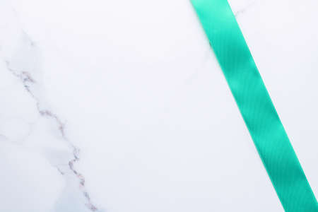 Holiday design, greeting card and vintage gift concept - Green silk ribbon on marble background, top viewの写真素材