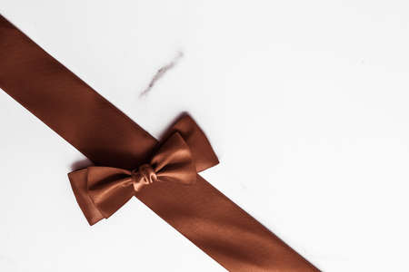 Holiday gift, decoration and sale promotion concept - Chocolate brown silk ribbon on marble background, flatlayの写真素材