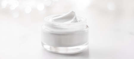 Cosmetic branding, gift and spa concept - Facial cream moisturizer jar on holiday glitter...