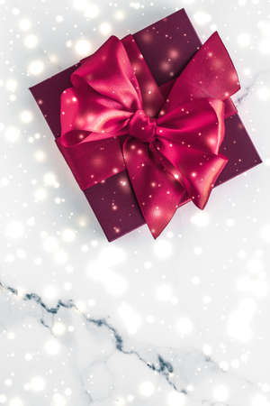 New Years Eve celebration, wrapped luxury boxes and cold season concept - Winter holiday gifts with cherry silk bow and glowing snow on frozen marble background, Christmas presents surpriseの写真素材