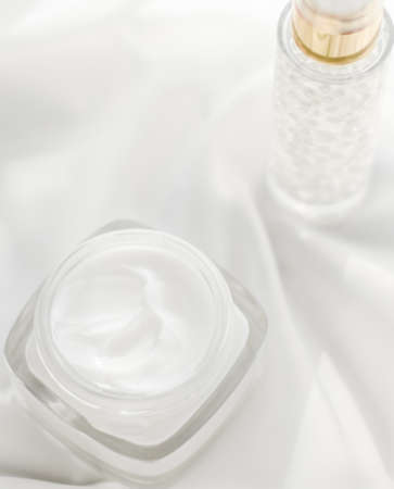 Cosmetic branding, moisturizing and spa concept - Face cream moisturizer jar and serum gel on white...
