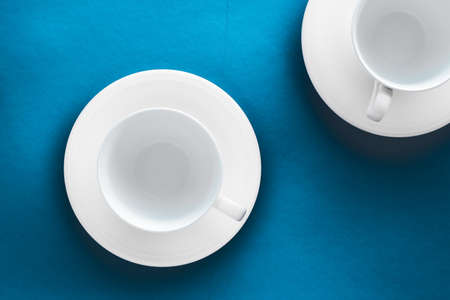 Kitchen, table decor and drinks menu concept - White tableware crockery set, empty cup on blue flatlay backgroundの写真素材