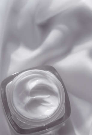Cosmetic branding, toiletries and spf concept - Face cream moisturizer jar on silk background, moisturizing skin care lotion and lifting emulsion, anti-age cosmetics for luxury beauty skincare brandの写真素材