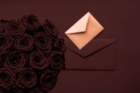 Holidays gift, floral present and happy relationship concept - Love letter and flowers delivery on Valentines Day, luxury bouquet of roses and card on chocolate background for romantic holiday designの写真素材