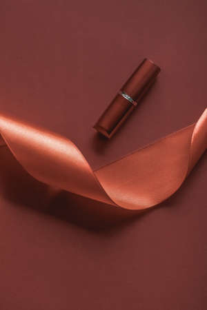 Cosmetic branding, glamour lip gloss and shopping sale concept - Luxury lipstick and silk ribbon on...