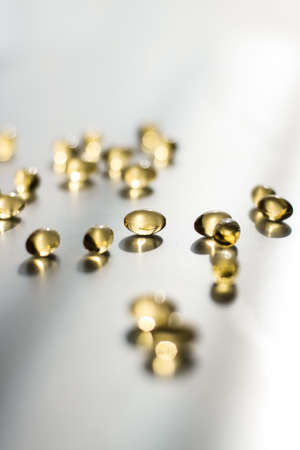 Pharmaceutical, branding and science concept -  Vitamin D and golden Omega 3 pills for healthy diet nutrition, fish oil food supplement pill capsules, healthcare and medicine as pharmacy backgroundの写真素材