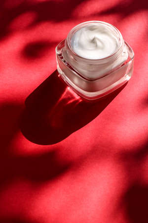 Anti-age moisturizer, luxe cosmetics and organic science concept - Moisturizing beauty face cream for sensitive skin, luxury spa cosmetic and natural clean skincare product on red backgroundの写真素材
