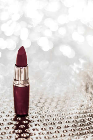 Cosmetic branding, sale and glamour concept - Chocolate lipstick on silver Christmas, New Years and Valentines Day holiday glitter background, make-up and cosmetics product for luxury beauty brandの写真素材