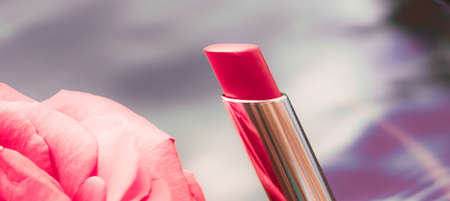 Cosmetic branding, luxe and fashion concept - Pink lipstick and rose flower on liquid background, waterproof glamour make-up and lip gloss cosmetics product for luxury beauty brand holiday designの写真素材